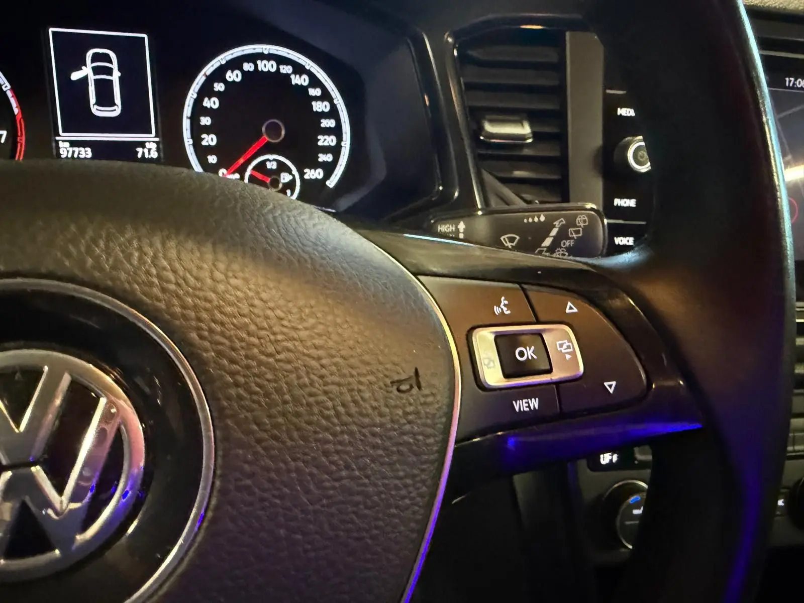 Gros plan sur le volant multifonctions en cuir du Volkswagen T-Roc 2019 avec tableau de bord et commandes visibles.