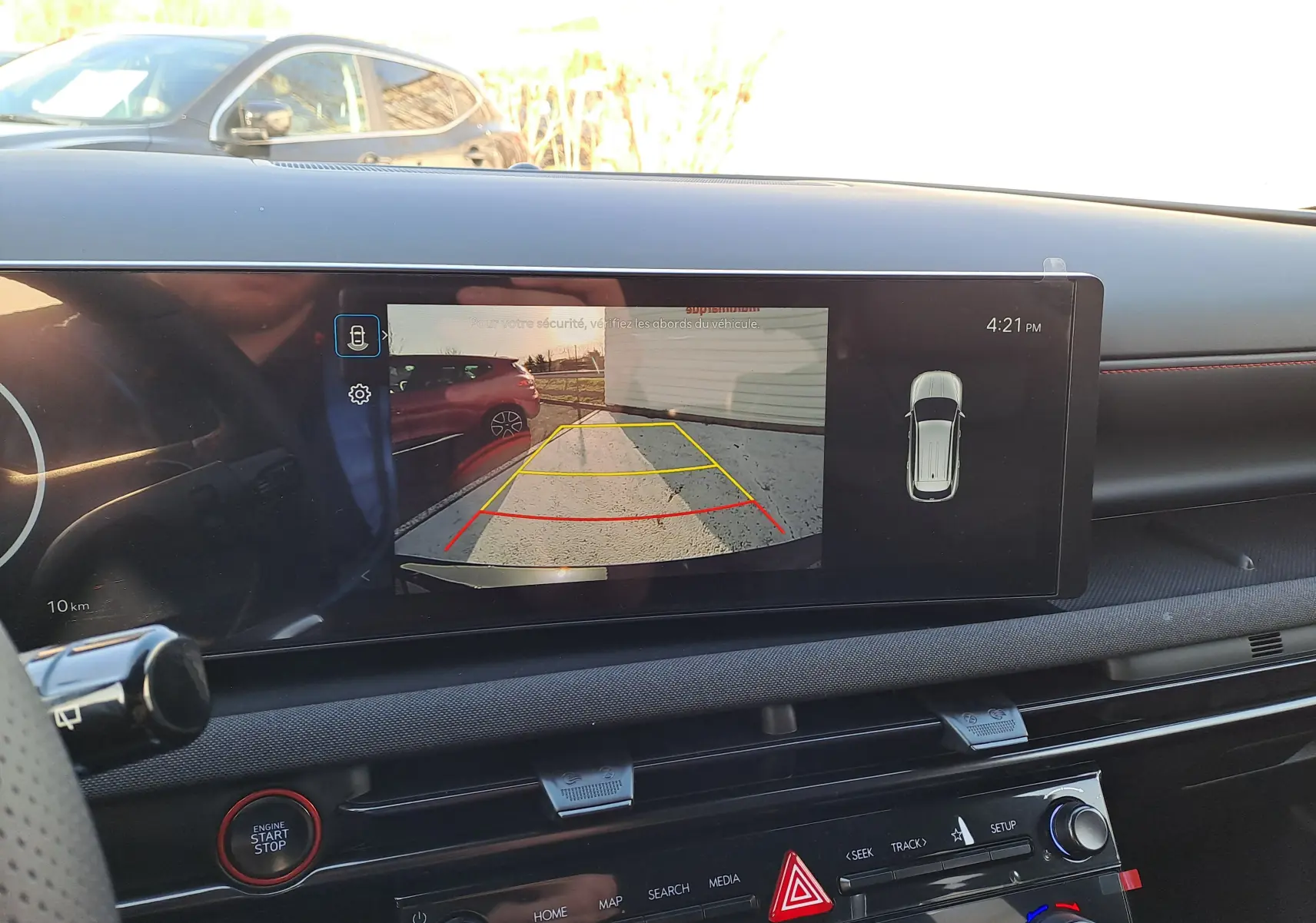 Vue intérieure du tableau de bord du Hyundai Tucson 2025 avec écran de caméra de recul affichant l'arrière du véhicule en Abyss Black.