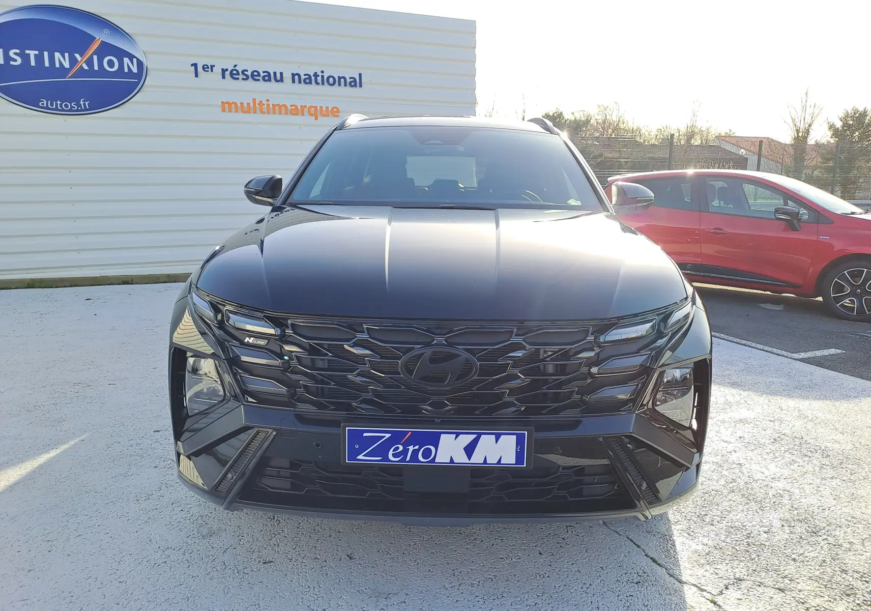 Vue frontale d'un Hyundai Tucson 2025 hybride en noir abyss, avec calandre noire et badge N-Line visible.