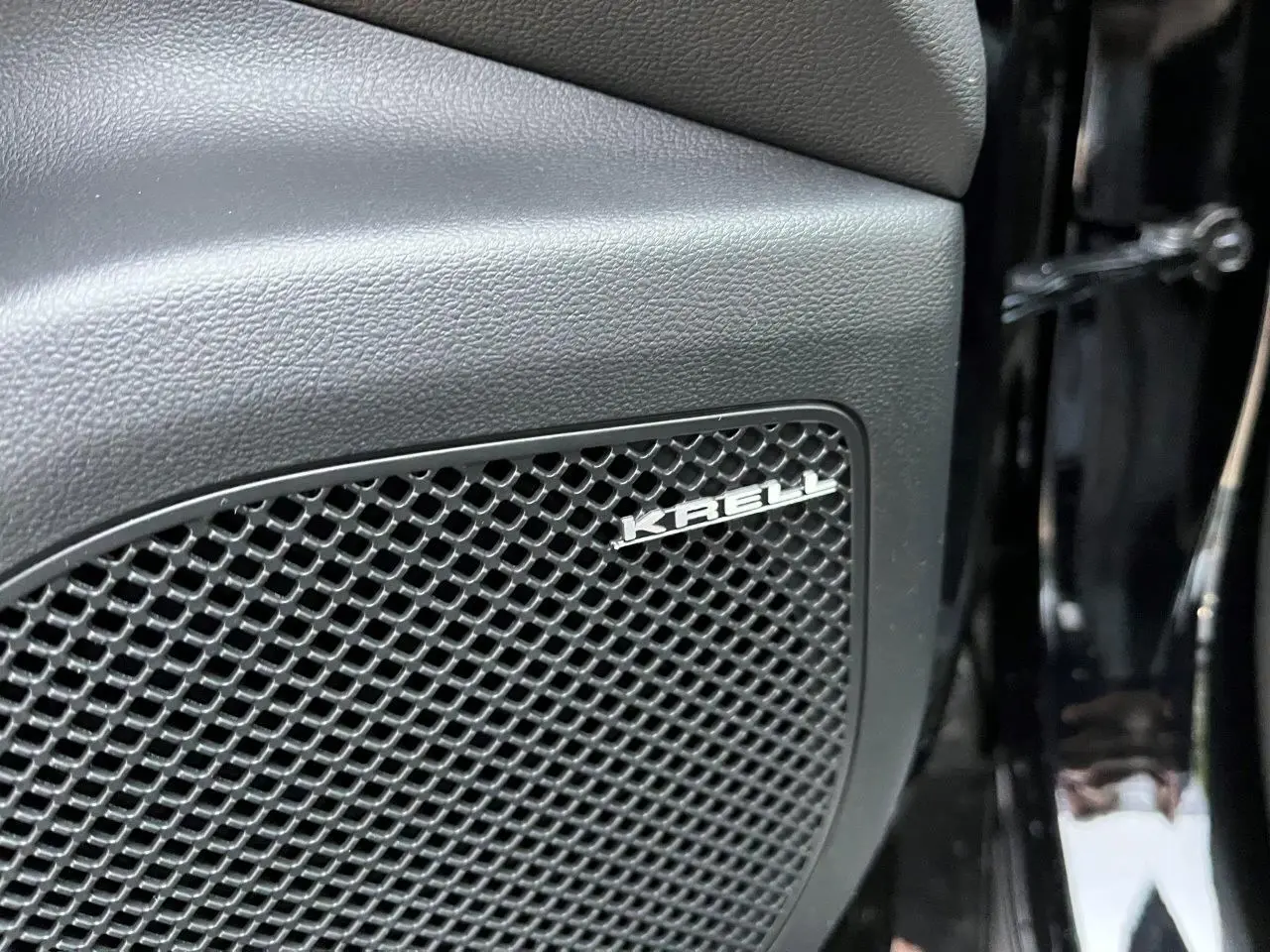 Gros plan sur le haut-parleur Krell intégré dans la porte intérieure d’un Hyundai Tucson 2025 couleur Abyss Black.