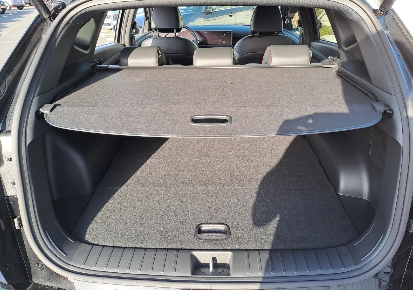 Coffre ouvert du Hyundai Tucson 2025 noir, vue arrière montrant la plage arrière et l’espace de chargement vide.