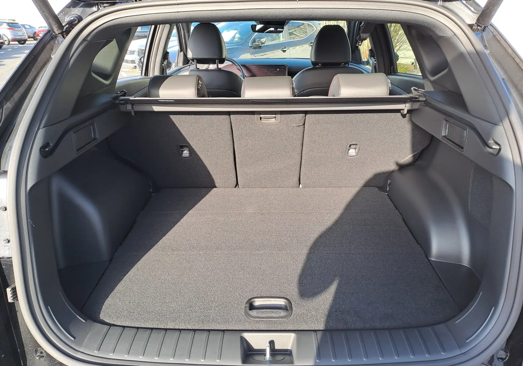 Vue arrière du coffre spacieux du Hyundai Tucson 2025 Abyss Black, avec banquette arrière et intérieur noir visibles.