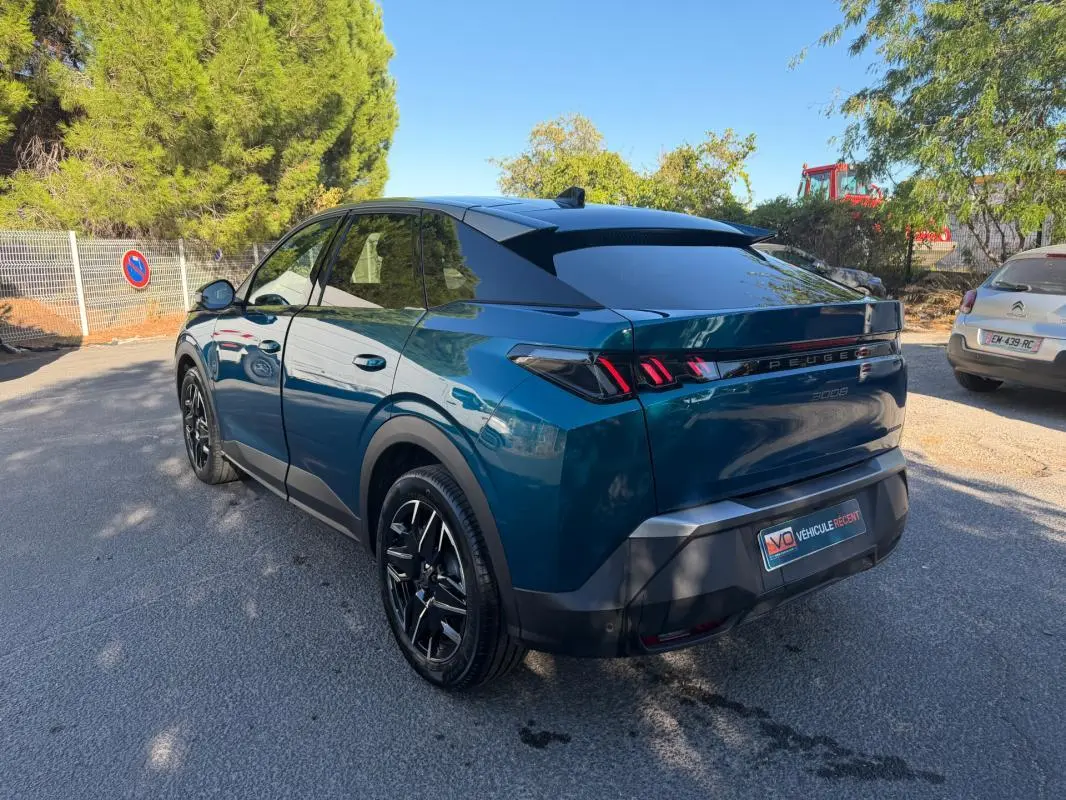 Peugeot 3008 Hybrid bleu en 3/4 arrière droit, avec feux arrière distinctifs et toit noir brillant.