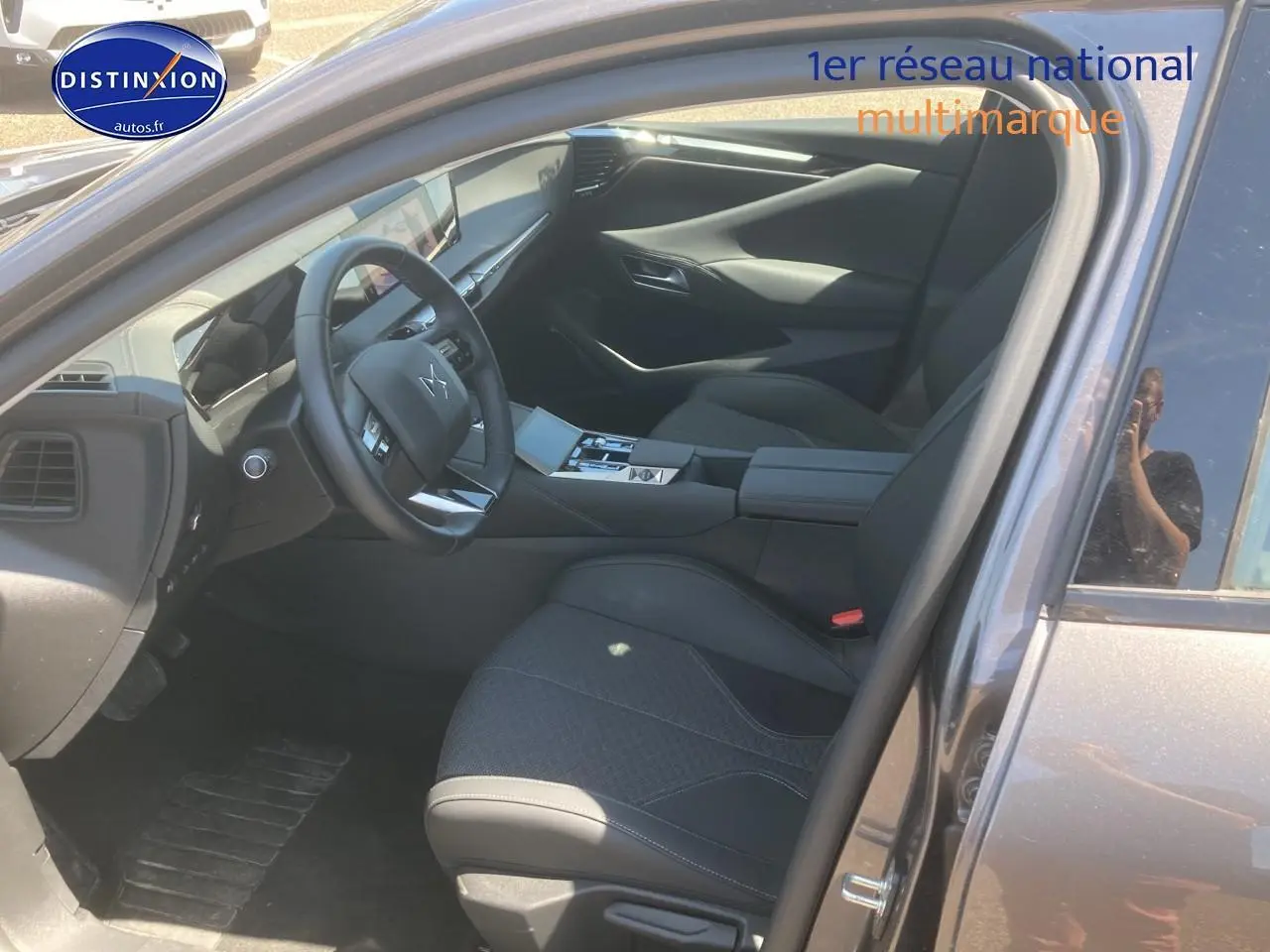 Intérieur de la DS4 E-tense 225 gris platinium, vue côté conducteur avec volant cuir et console centrale moderne.