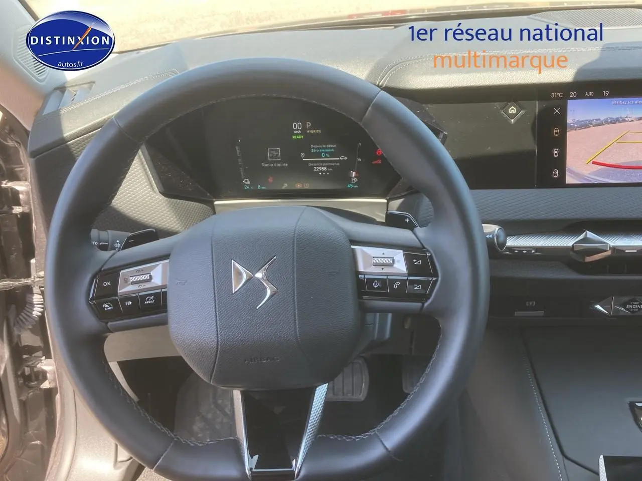 Vue intérieure centrée sur le volant cuir DS d'un DS4 E-tense 225 gris platinium avec tableau de bord numérique et écran tactile.