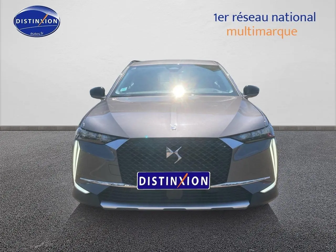 Vue frontale du DS4 E-tense 225 Cross Trocadero gris platinium avec calandre noire et feux LED verticaux allumés.