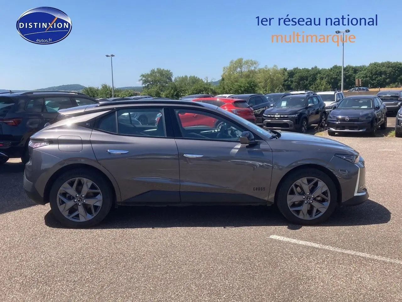 Profil côté gauche du DS4 E-tense 225 Cross Trocadero gris platinium garé en extérieur sur parking.