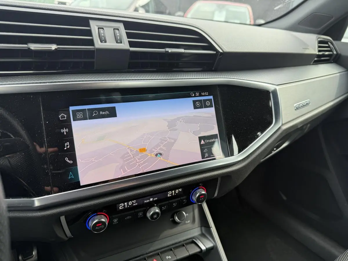 Détail de la console centrale avec écran tactile de navigation et commandes de climatisation dans l'Audi Q3 S Line noir 2019