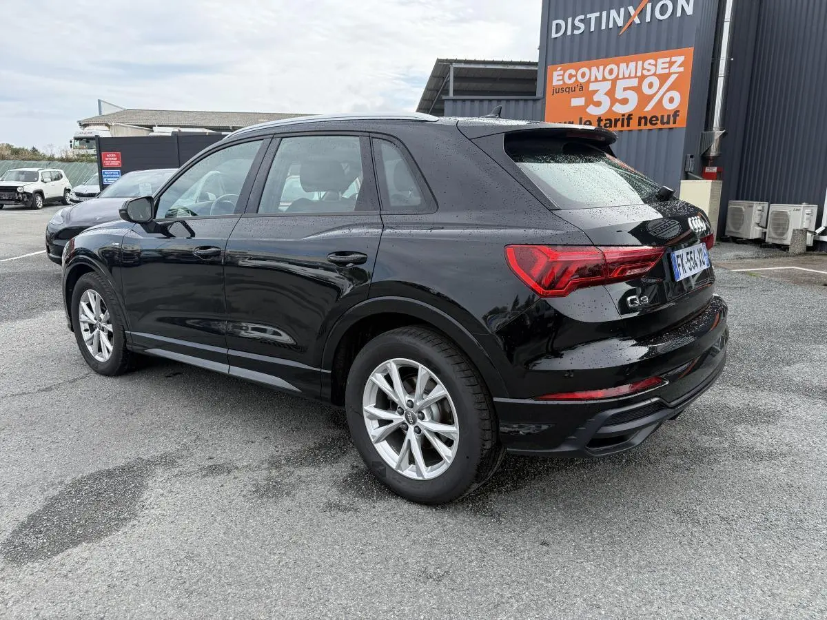 Audi Q3 Quattro 2.0 35 TDI S Line noir métallisé vue 3/4 arrière droit sur parking humide