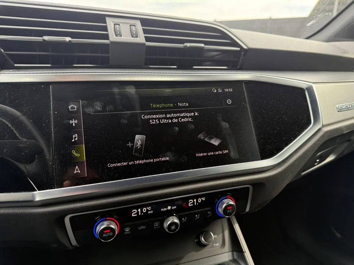 Vue rapprochée de la console centrale et écran tactile du tableau de bord de l'Audi Q3 noir 2019 Quattro S Line.
