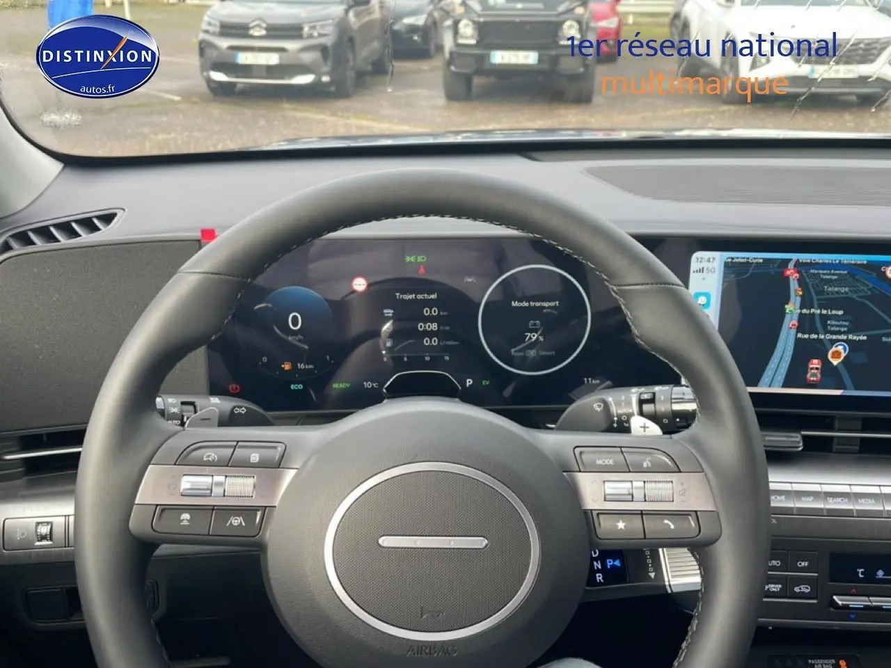 Vue intérieure centrée sur le volant cuir multifonction du Hyundai Kona 2025 avec tableau de bord numérique et écran tactile.