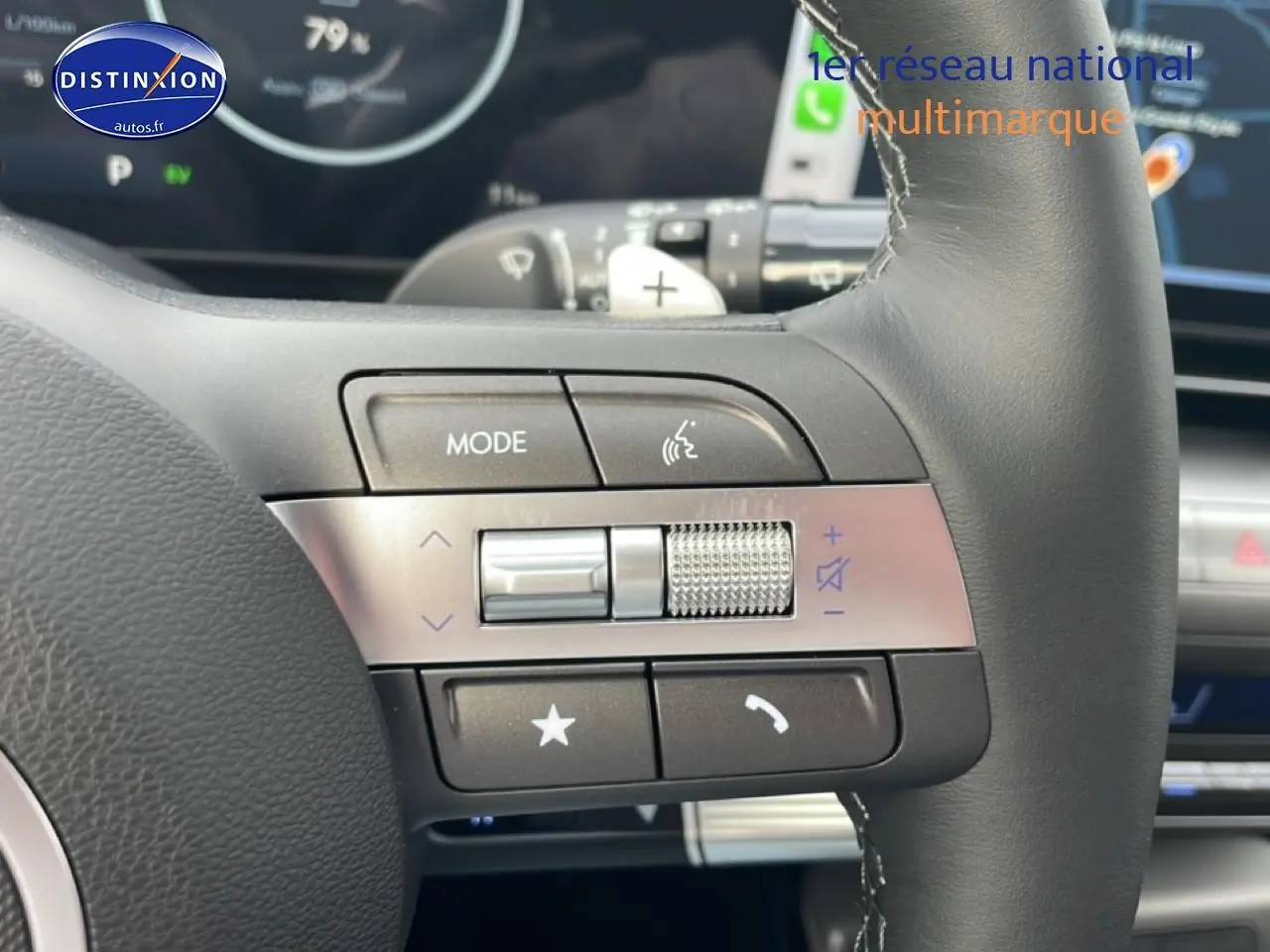 Gros plan sur les commandes gauche du volant cuir multifonction du Hyundai Kona bleu 2025, avec palettes au volant.