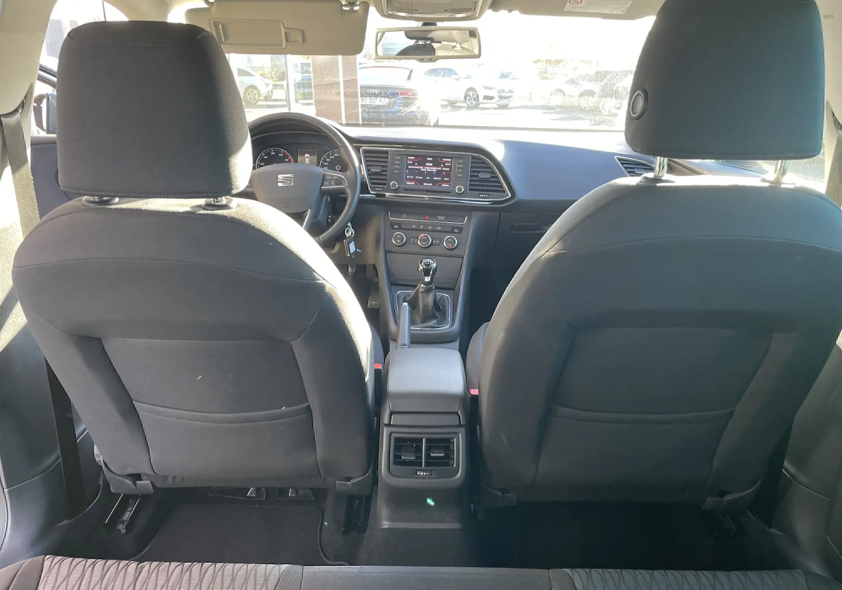 Vue intérieure arrière de la SEAT LEON ST 2013, montrant sièges avant noirs et tableau de bord avec écran tactile central.