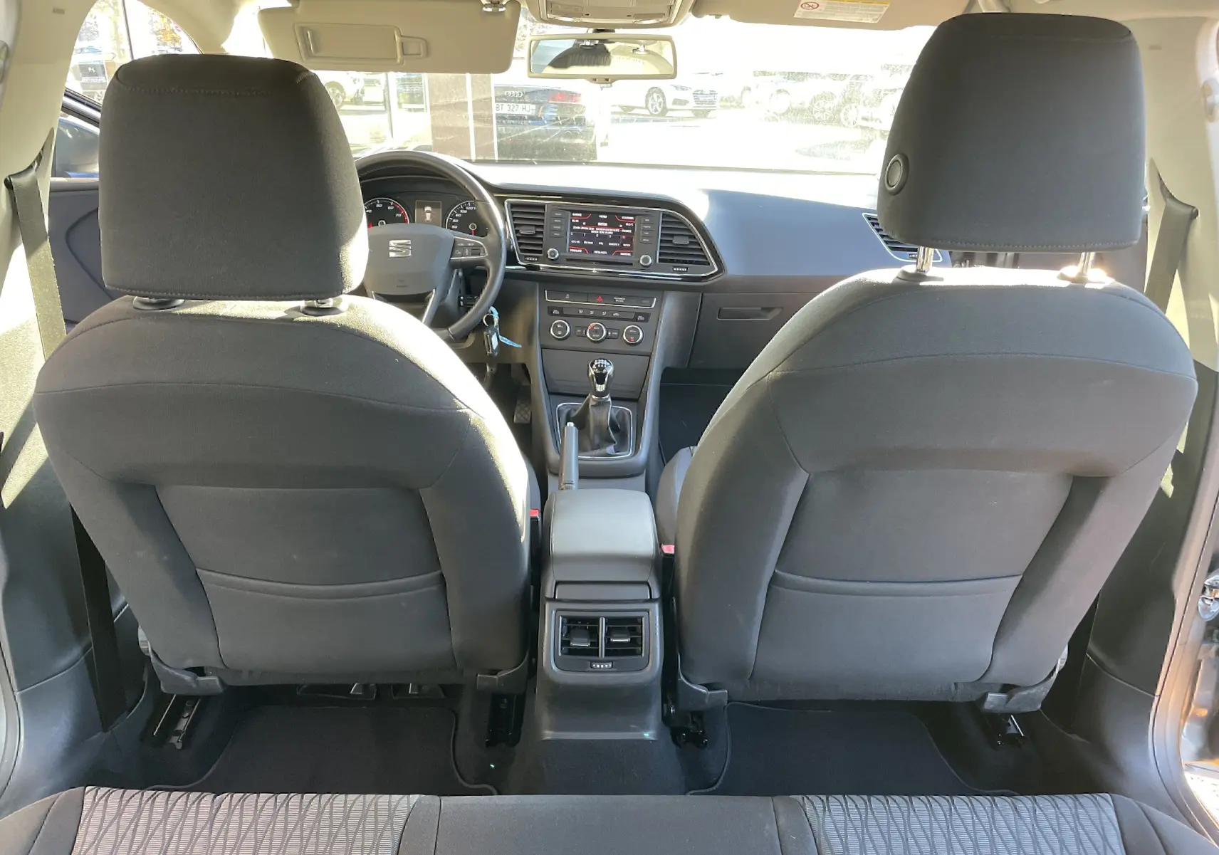 Intérieur noir et gris du SEAT LEON ST 2013, vue arrière des sièges avant et tableau de bord avec boîte manuelle.