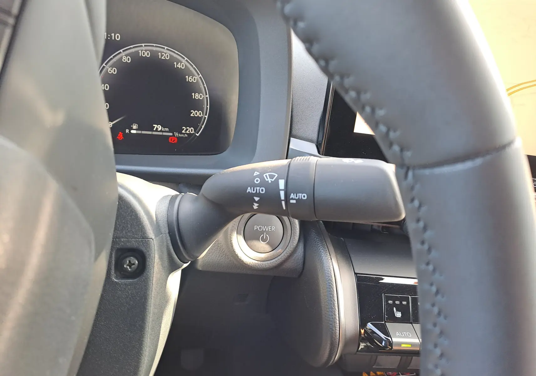 Vue rapprochée du tableau de bord du Toyota C-HR gris minéral 2025, avec bouton Power et commandes au volant visibles.