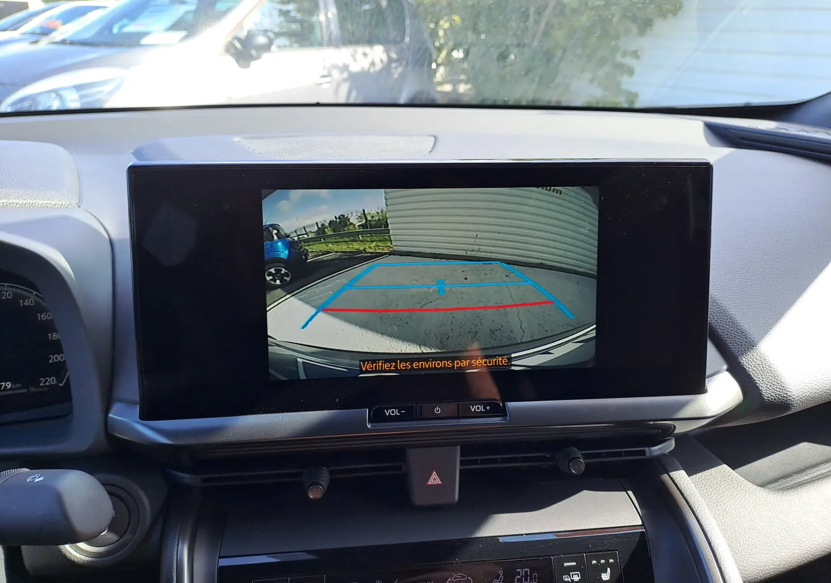 Écran central du Toyota C-HR gris minéral 2025 montrant la caméra de recul avec lignes de guidage colorées.