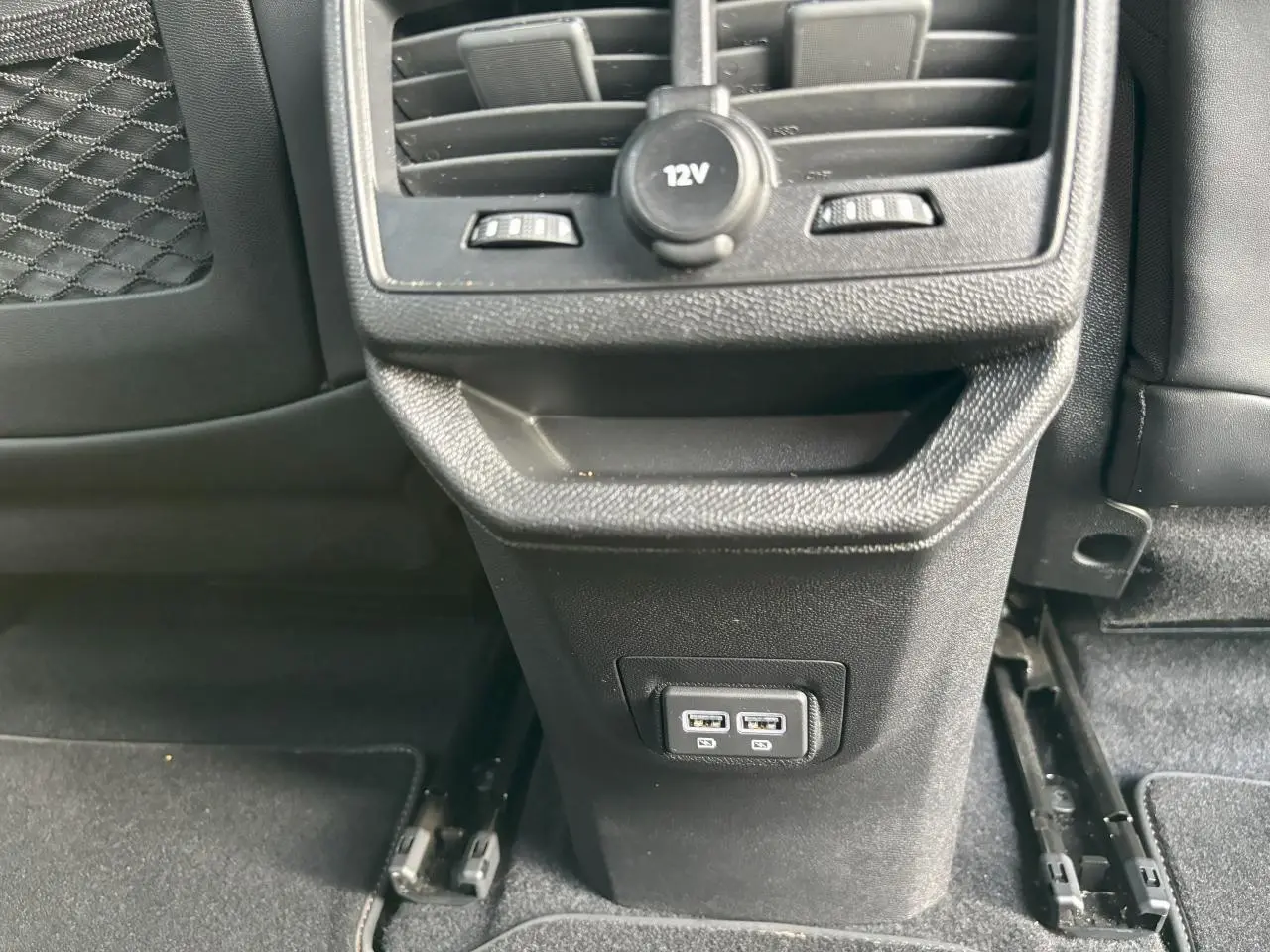 Vue rapprochée de la console arrière noire avec prises USB doubles et prise 12V du Peugeot 3008 GT blanc nacré.