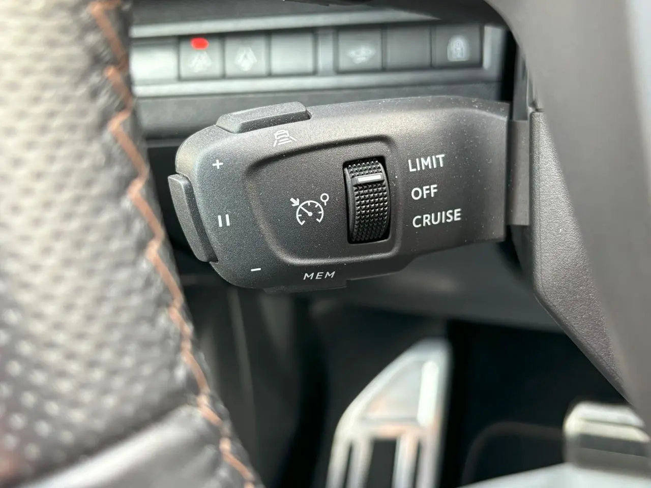 Gros plan sur la commande de régulateur de vitesse au volant cuir perforé du Peugeot 3008 blanc nacré 2024.