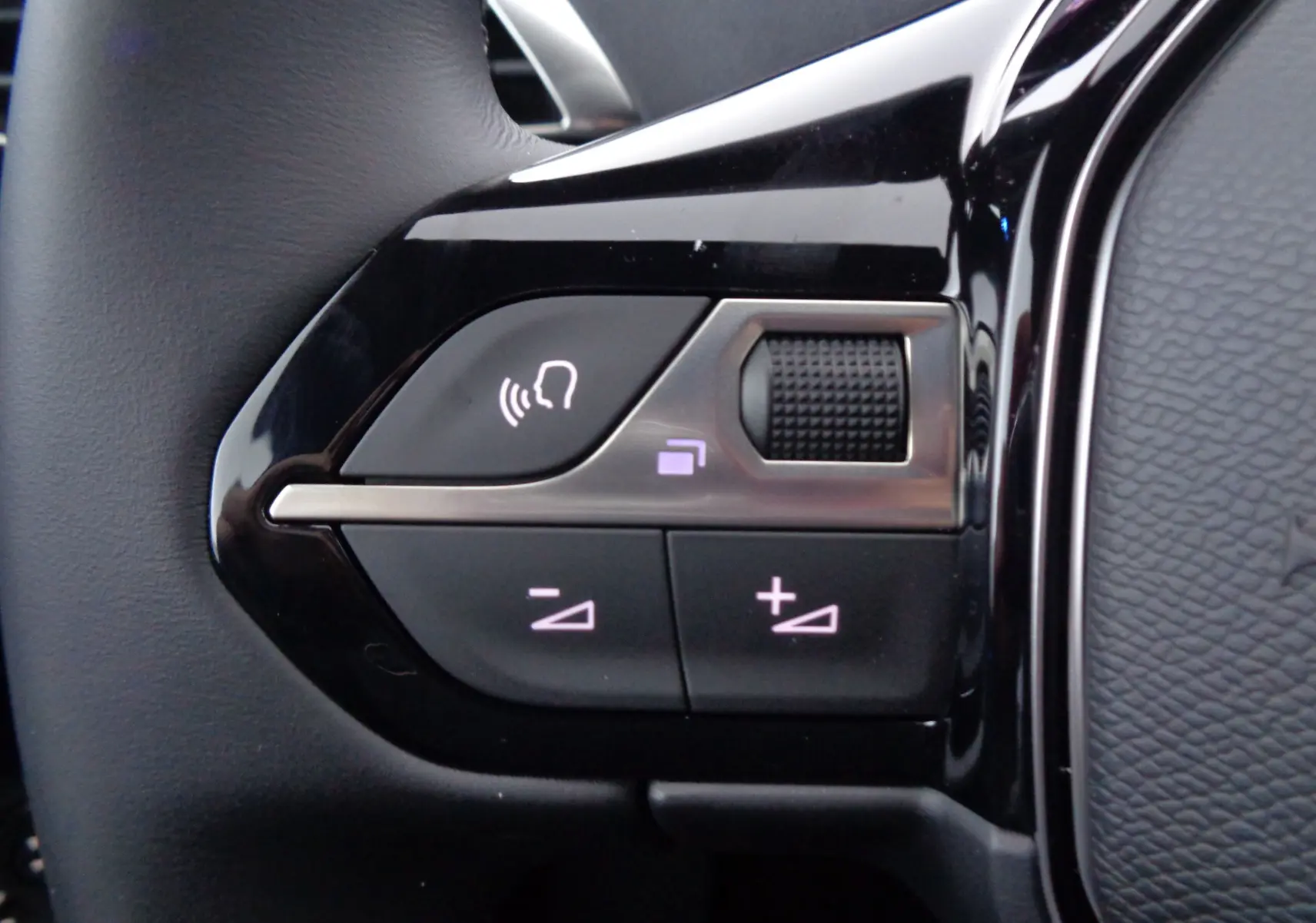 Gros plan sur les commandes noires du volant du Peugeot 3008 2023, avec boutons de volume et molette tactile.