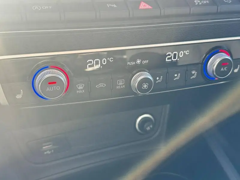 Panneau de climatisation digital de l'Audi Q2 35 TFSI 2023 avec réglages à 20°C et commandes rotatives bicolores.