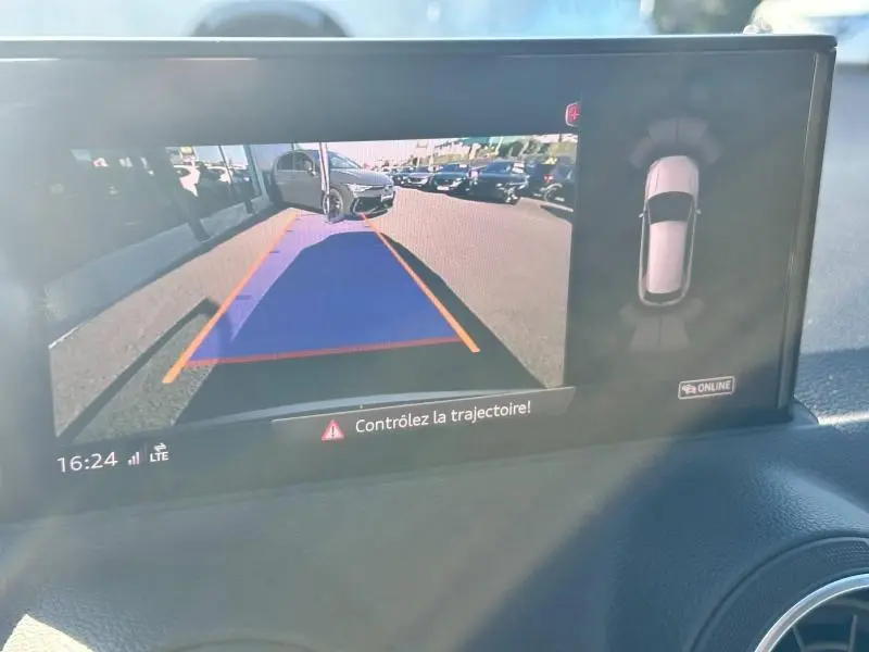 Vue caméra de recul montrant un Audi Q2 noir Mythic métallisé en stationnement avec lignes de guidage colorées.