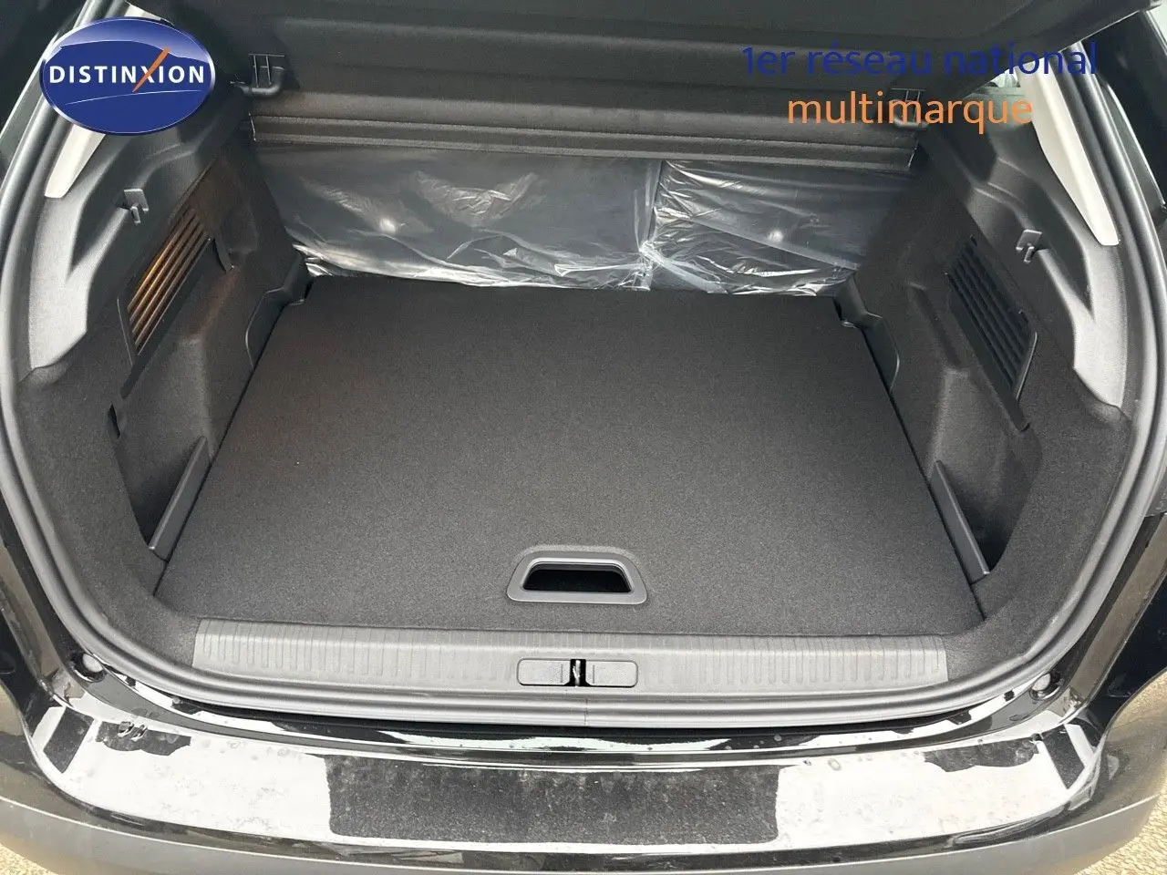 Coffre ouvert d'une Citroën C4 noire métal 2024, montrant un espace de chargement propre et spacieux.