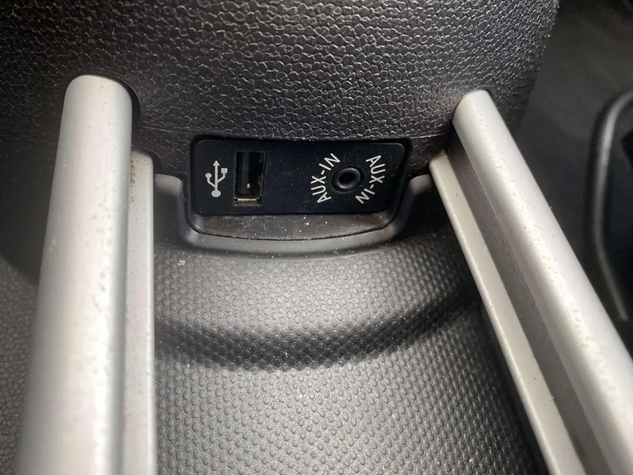 Gros plan sur la prise USB et AUX-IN du MINI Countryman gris clair, console centrale en plastique texturé noir.