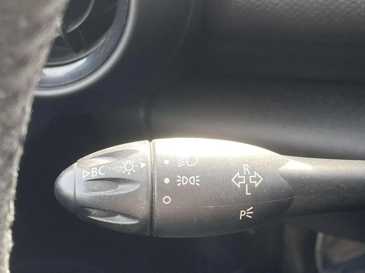 Gros plan sur la commande des clignotants et feux du MINI Countryman gris clair, intérieur noir.