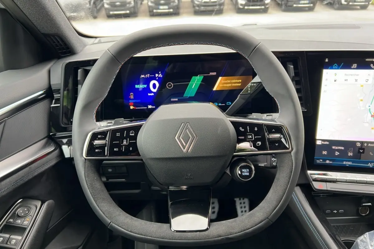 Vue intérieure centrée sur le volant du Renault Austral E-Tech 200 Esprit Alpine Plus avec tableau de bord numérique et écran tactile.
