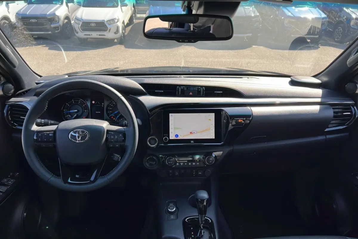 Vue intérieure du tableau de bord du Toyota Hilux 2025 gris atlas, avec écran tactile et volant multifonction.