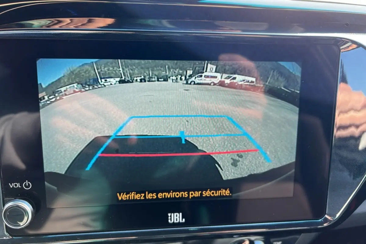 Vue caméra de recul du Toyota Hilux 4x4 gris atlas 2025 avec lignes d'aide au stationnement sur écran JBL.