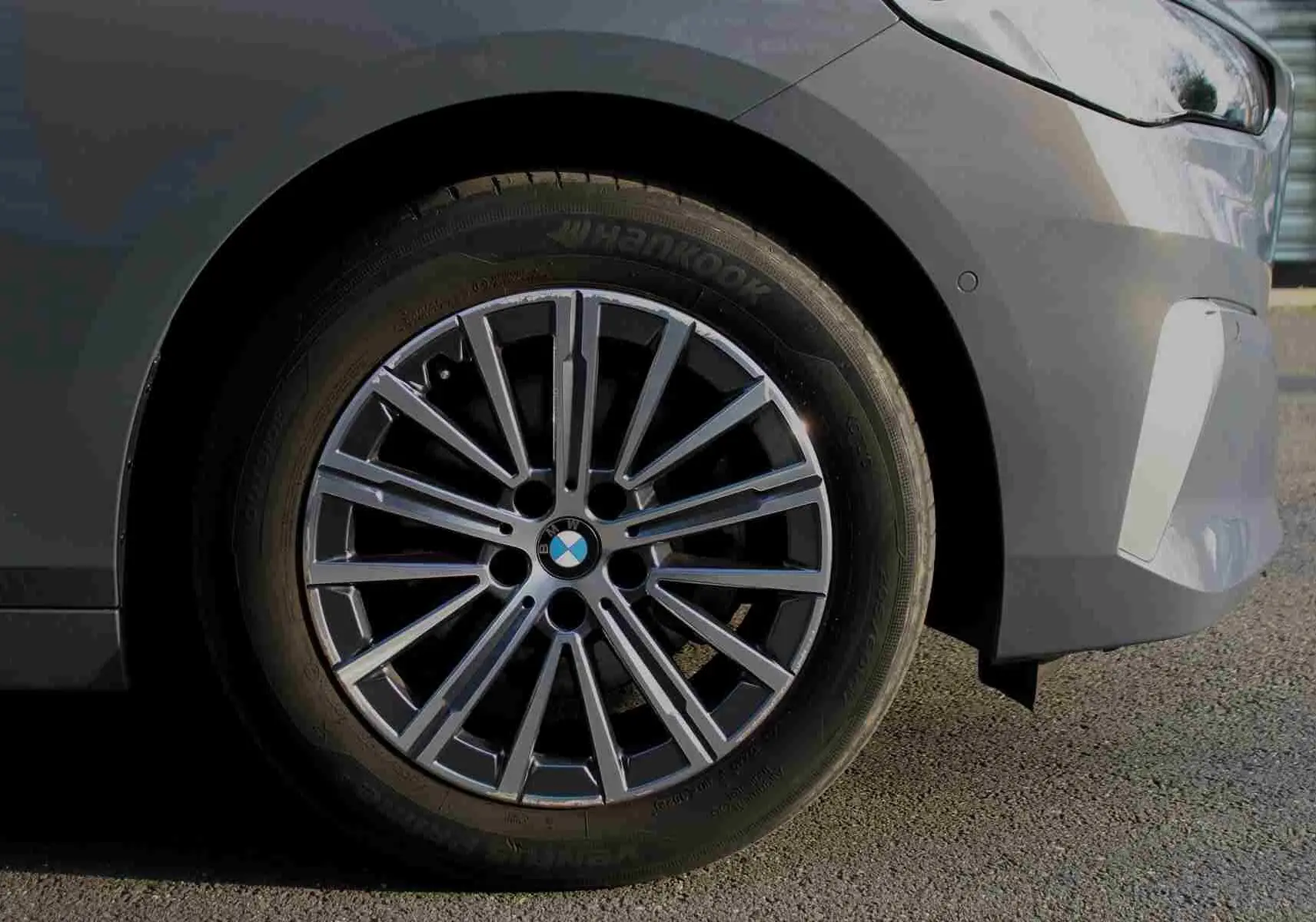 Gros plan sur la roue avant droite d'une BMW Série 2 Active Tourer gris Nardo avec jante alliage multi-branches.