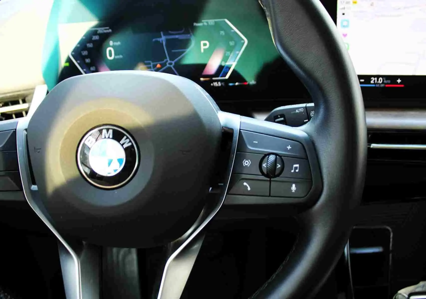 Gros plan sur le volant cuir noir de la BMW Série 2 Active Tourer 2023 avec commandes intégrées et tableau de bord digital.