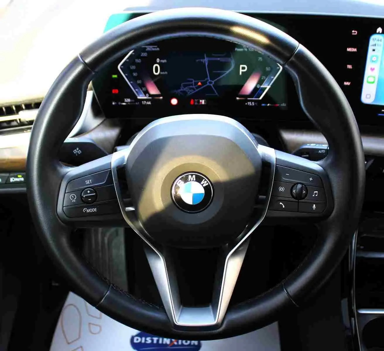 Gros plan sur le volant cuir noir et le tableau de bord numérique d'une BMW Série 2 Active Tourer gris Nardo.