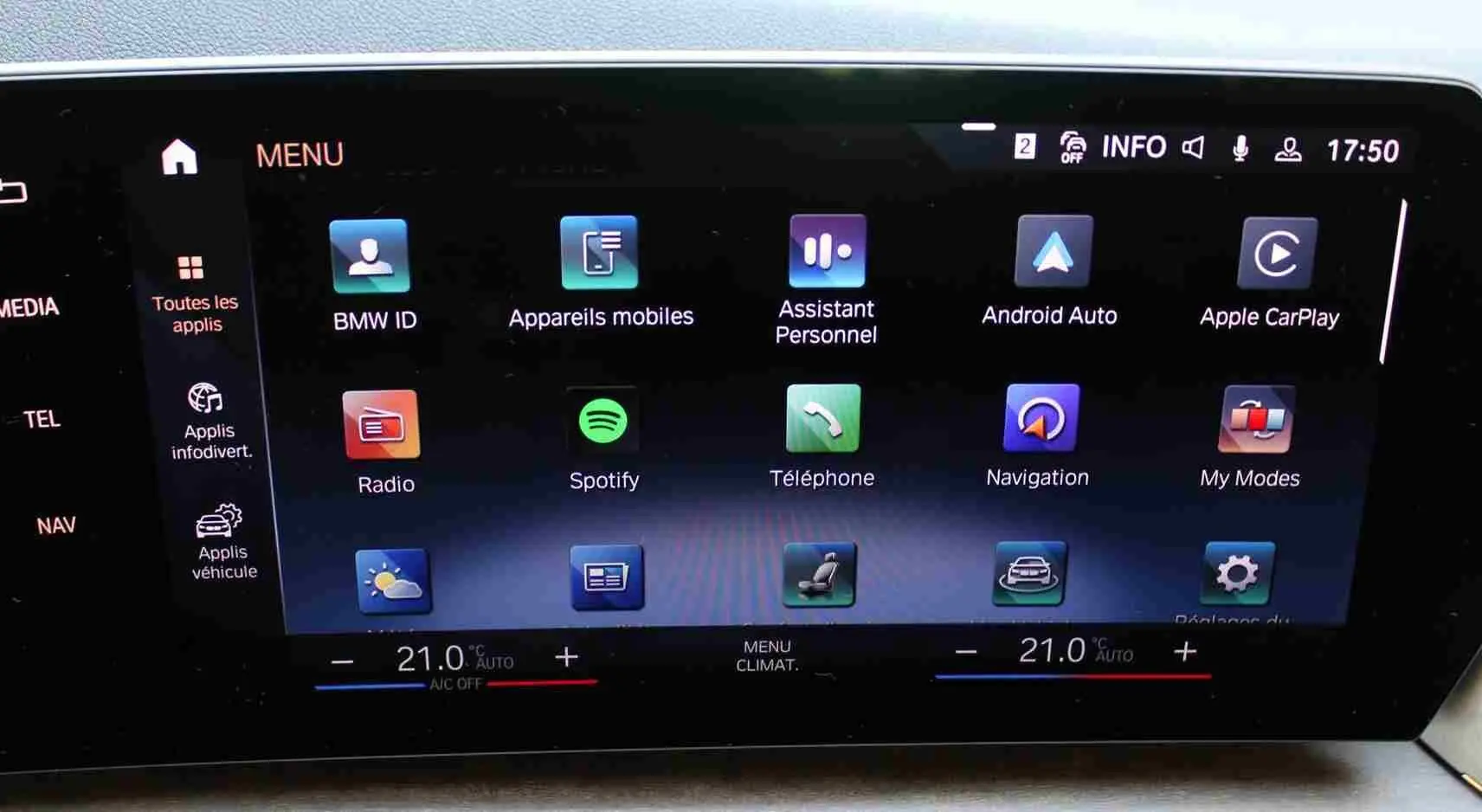 Écran tactile central de la BMW Série 2 Active Tourer 218d 2023 affichant les applications connectées et la climatisation à 21°C.