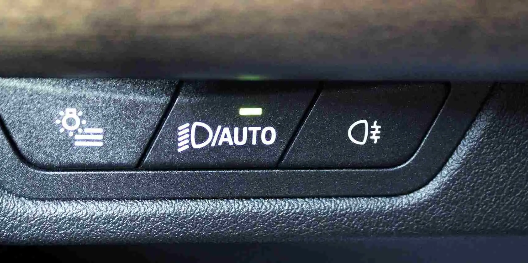 Gros plan sur les boutons de commande des phares automatiques et antibrouillard du BMW Série 2 Active Tourer gris Nardo.