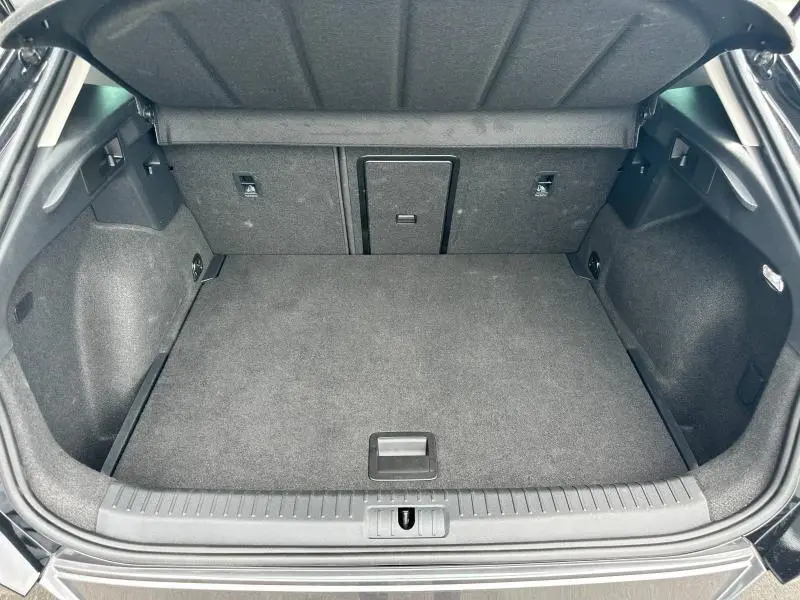 Coffre ouvert vu de l'arrière du CUPRA Formentor noir Minuit métallisé, espace de chargement propre et bien agencé.