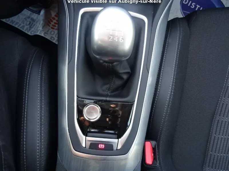 Gros plan sur la console centrale de la Peugeot 308 SW noire, montrant le levier de vitesses manuel et le frein de parking électrique.