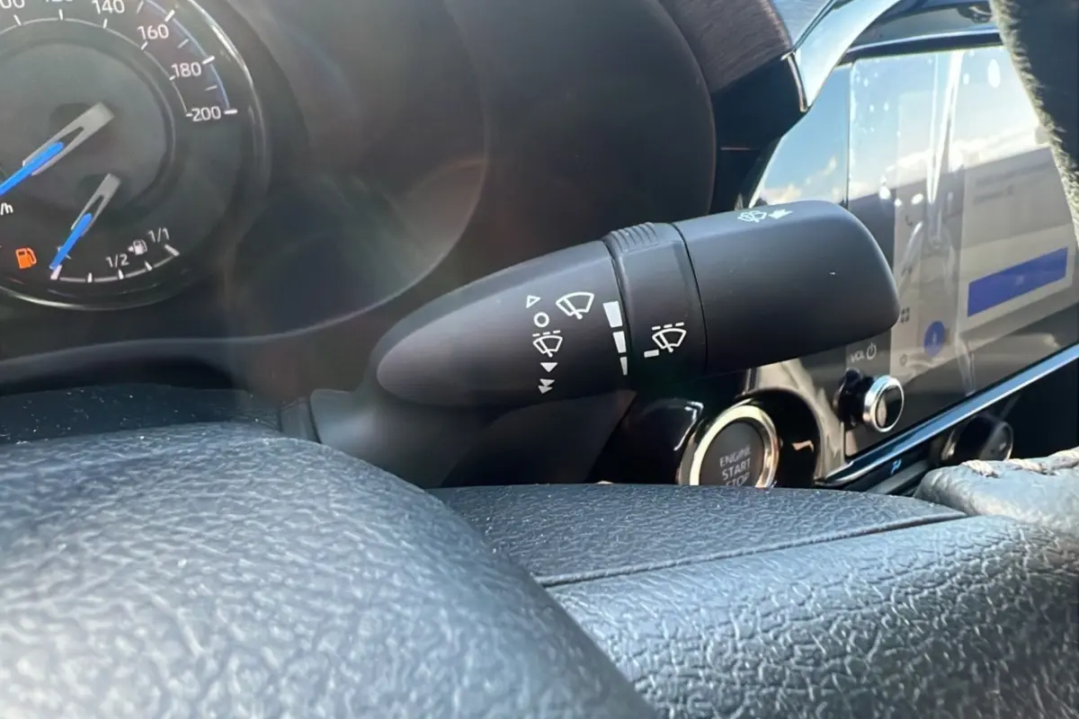 Gros plan sur la commande d’essuie-glace et le tableau de bord du Toyota Hilux 2025 gris atlas, version Invincible.