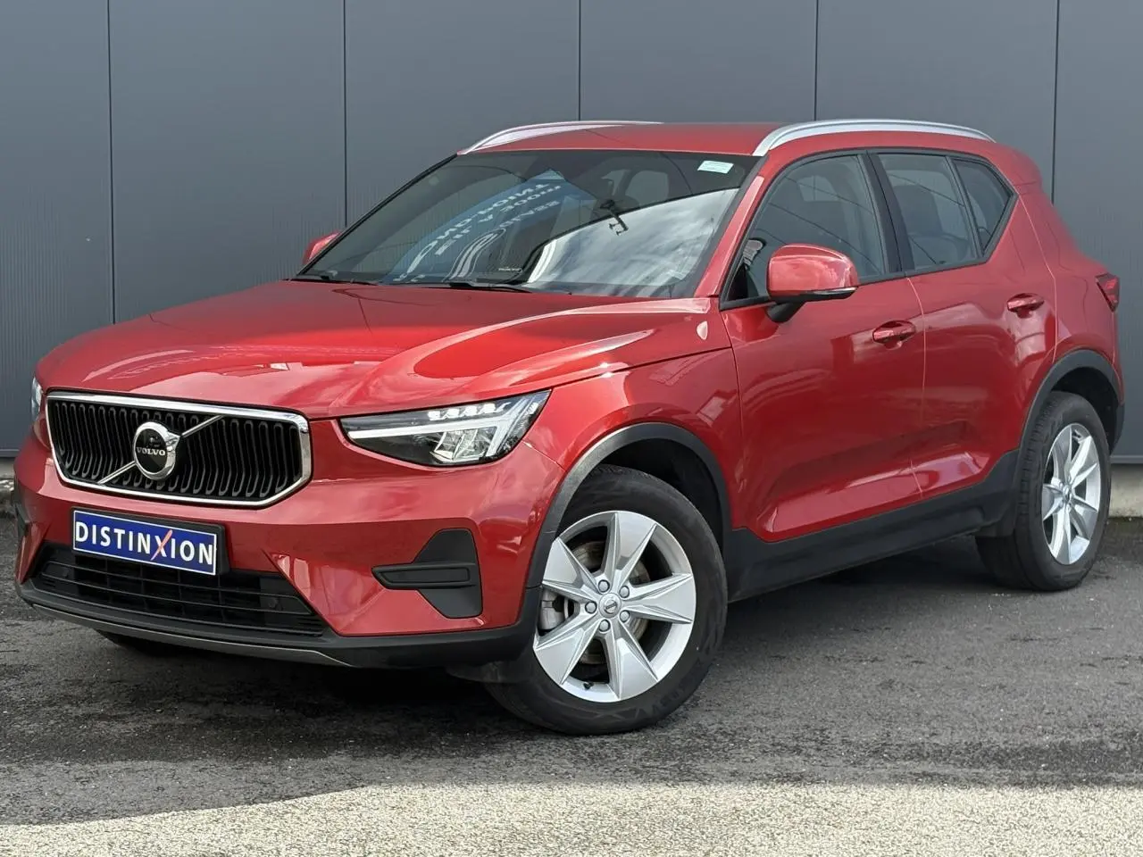 Volvo XC40 rouge Fusion vue 3/4 avant droit, avec jantes alliage 18 pouces et calandre chromée distinctive.