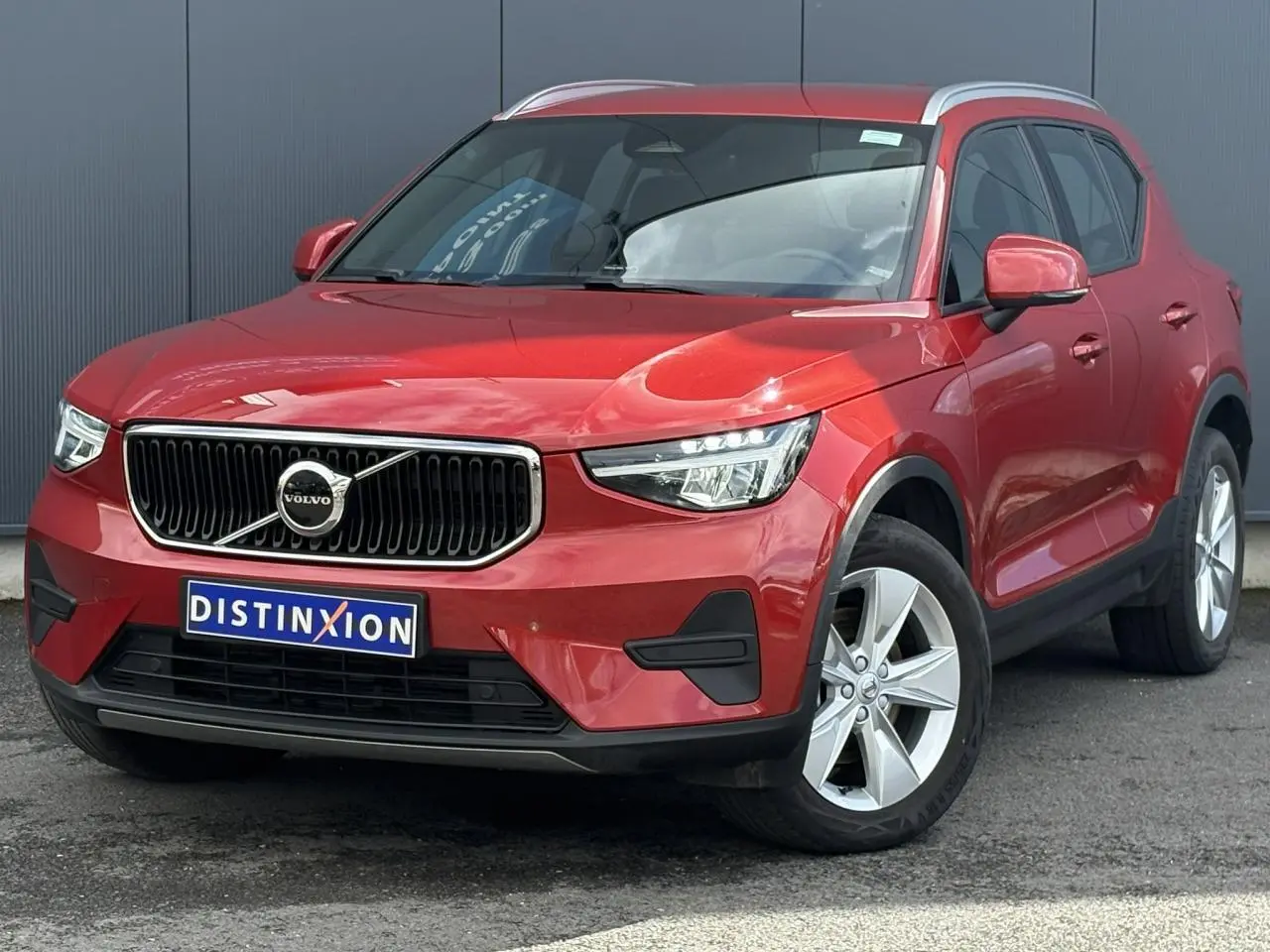 Volvo XC40 B3 MHEV rouge Fusion vue 3/4 avant droit avec calandre chromée et jantes alliage 18 pouces.