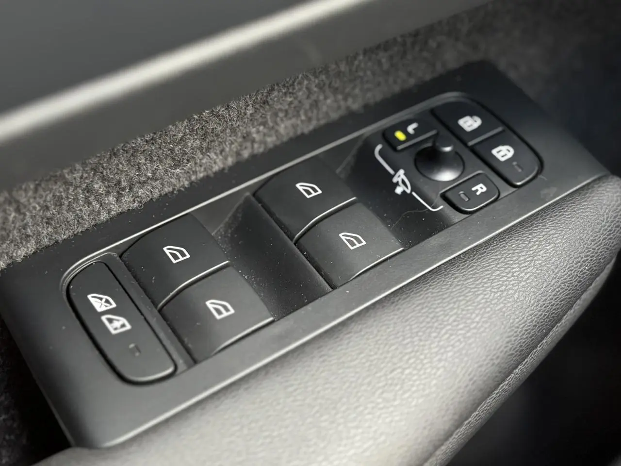 Panneau de commandes des vitres et rétroviseurs côté conducteur dans un Volvo XC40 2024.