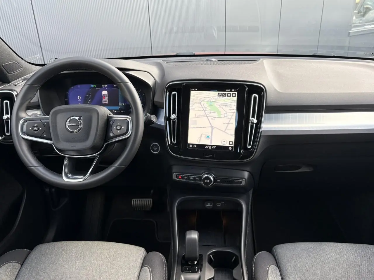 Intérieur du Volvo XC40 2024, vue frontale du tableau de bord avec écran tactile et volant multifonction.