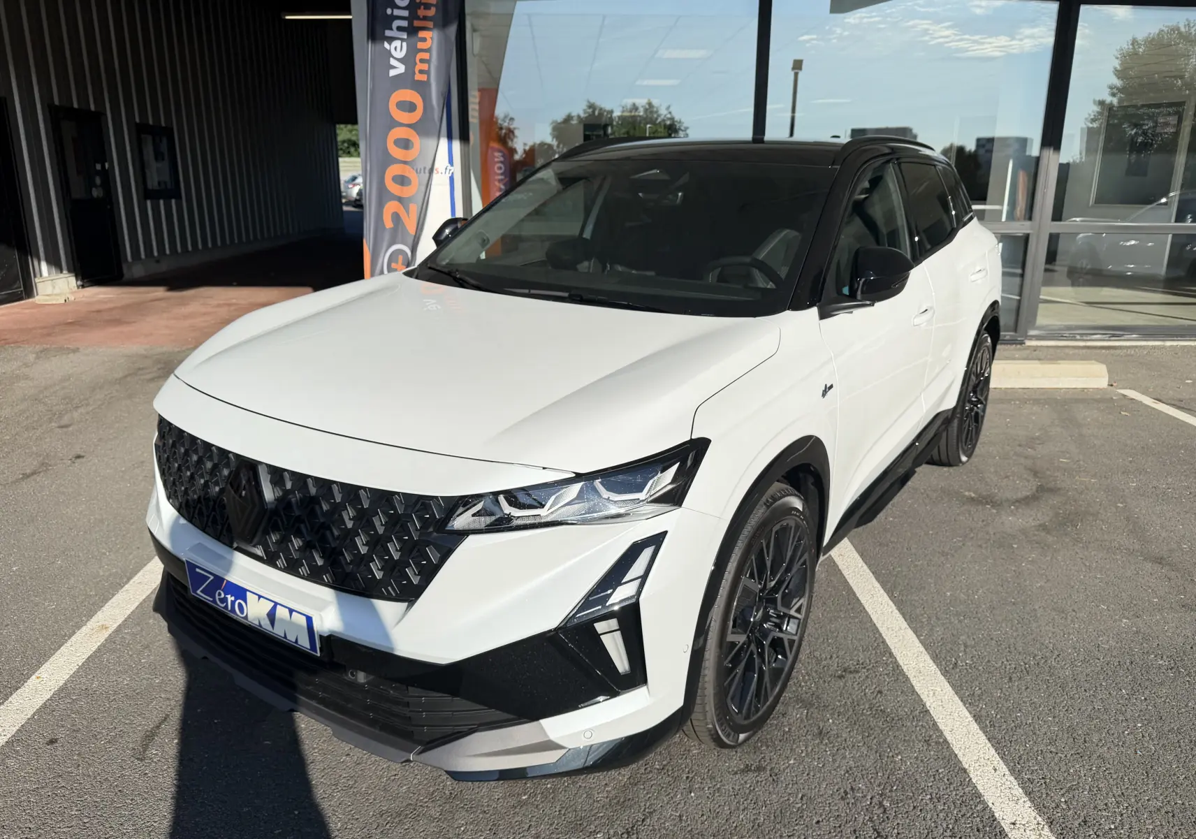 Renault Austral E-Tech 200 Esprit Alpine blanc nacré avec toit noir, vue 3/4 avant droit, jantes noires 20 pouces.