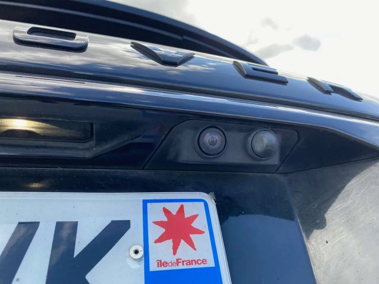 Gros plan sur la caméra de recul et la plaque arrière du Range Rover Sport noir, détail du hayon visible.