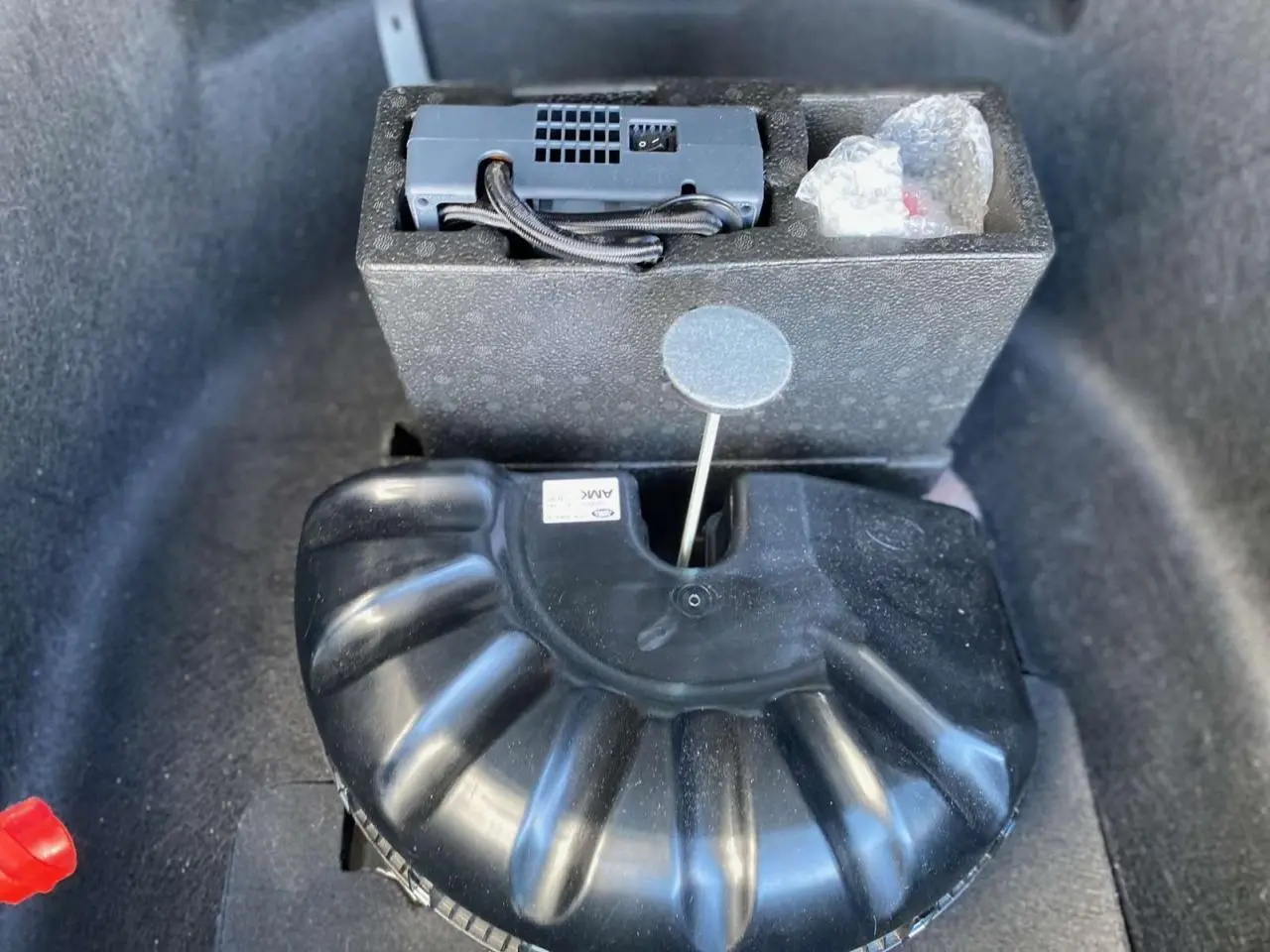 Gros plan sur le caisson noir de rangement dans le coffre du Range Rover Sport SVR 2016, avec accessoires visibles.