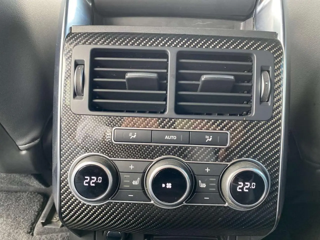 Détail de la console arrière en carbone du Range Rover Sport SVR 2016 avec commandes climatisation à 22°C.