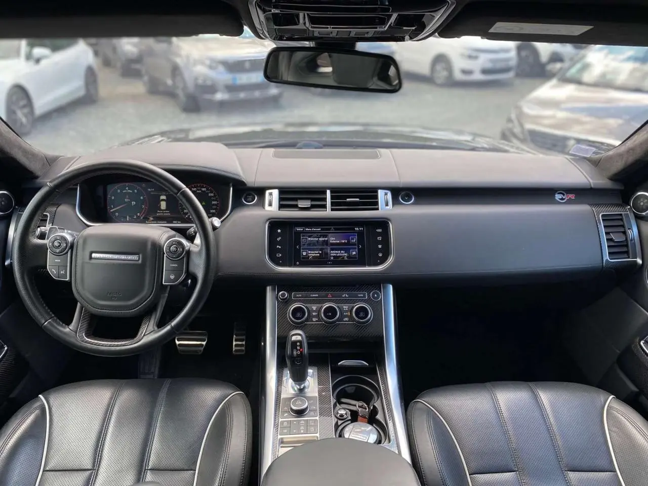 Intérieur noir du Range Rover Sport SVR 2016 vu de face, avec volant cuir, console centrale et tableau de bord numérique.