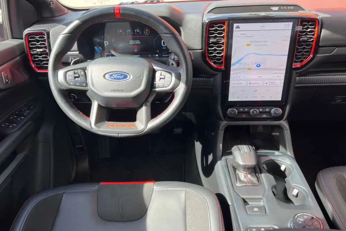 Intérieur du Ford Ranger Raptor 2025 en gris, vue de face sur le volant, tableau de bord numérique et écran tactile central.