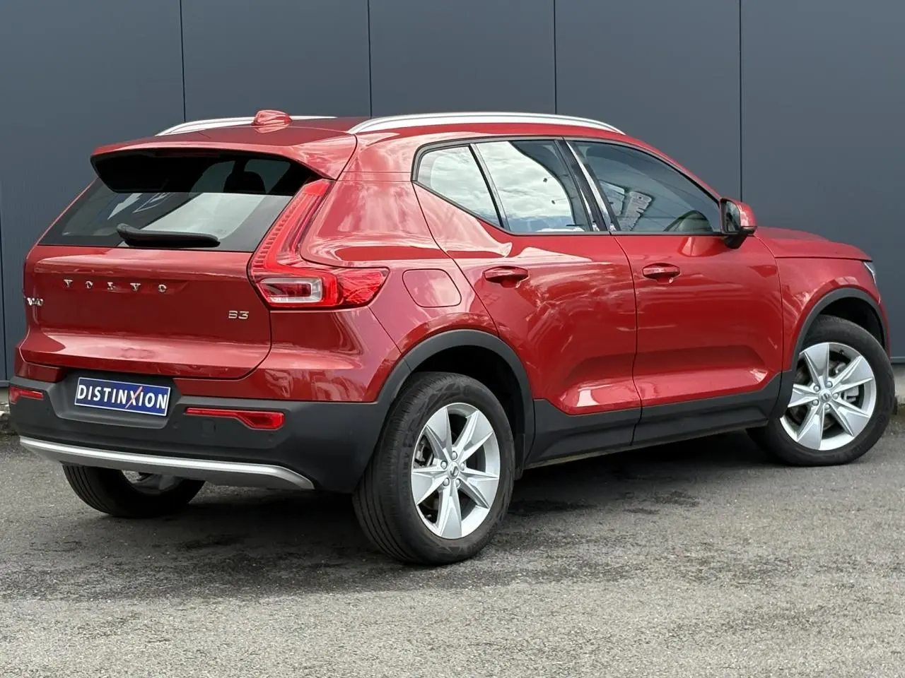Volvo XC40 B3 MHEV rouge Fusion vue 3/4 arrière côté gauche, avec jantes alliage 18 pouces et toit blanc.